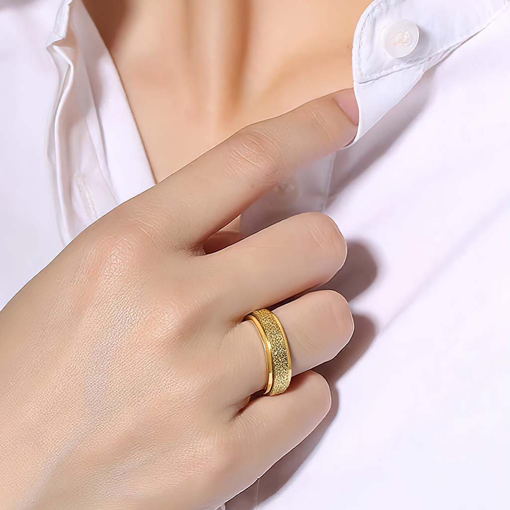 Woman hand wearing gold spinner ring white